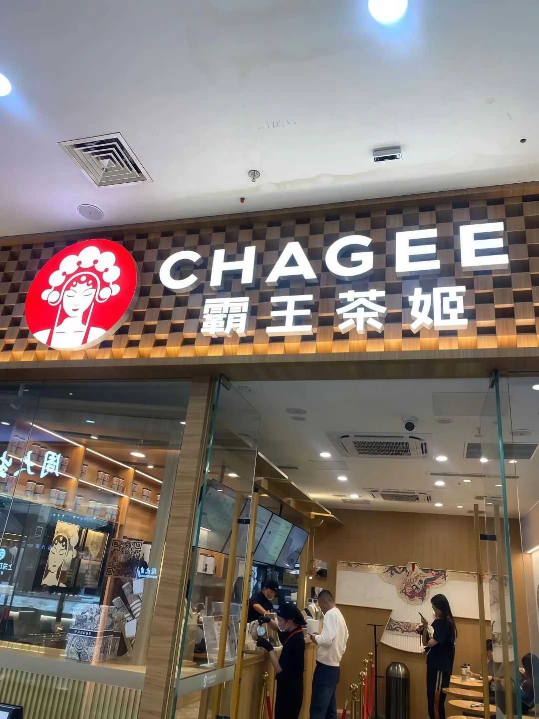 “霸王茶姬”门店外观,店内顾客在点单,充满中式茶饮氛围 “对象查岗,就用这些图片表情包” 霸王茶姬门店,古色古香设计,顾客正在店内享受茶饮时光 ...